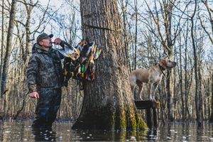 man blowing whistle with hunting dog wearing camo and Lite Boots.